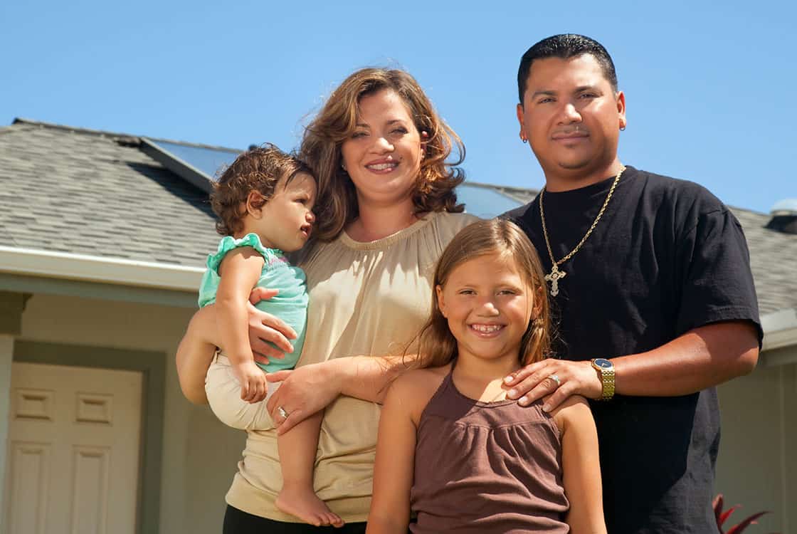 Family standing by house
